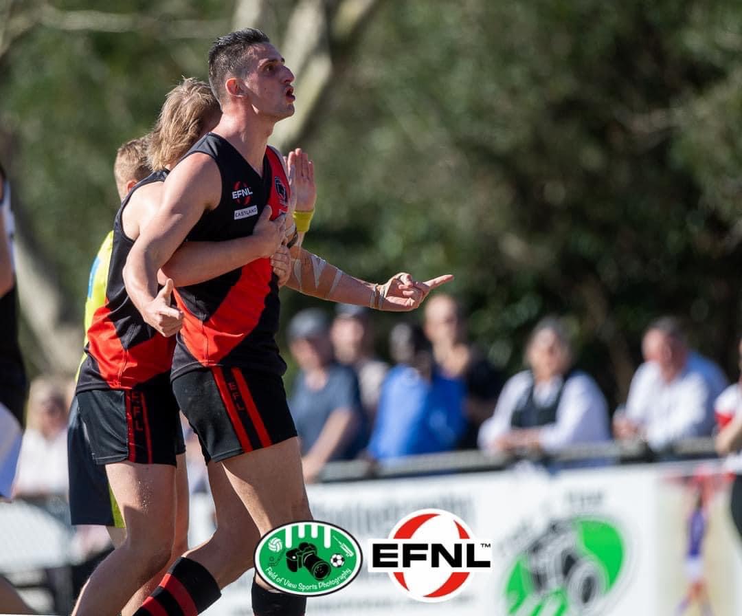 Footballer in black and red preparing for a marking contest