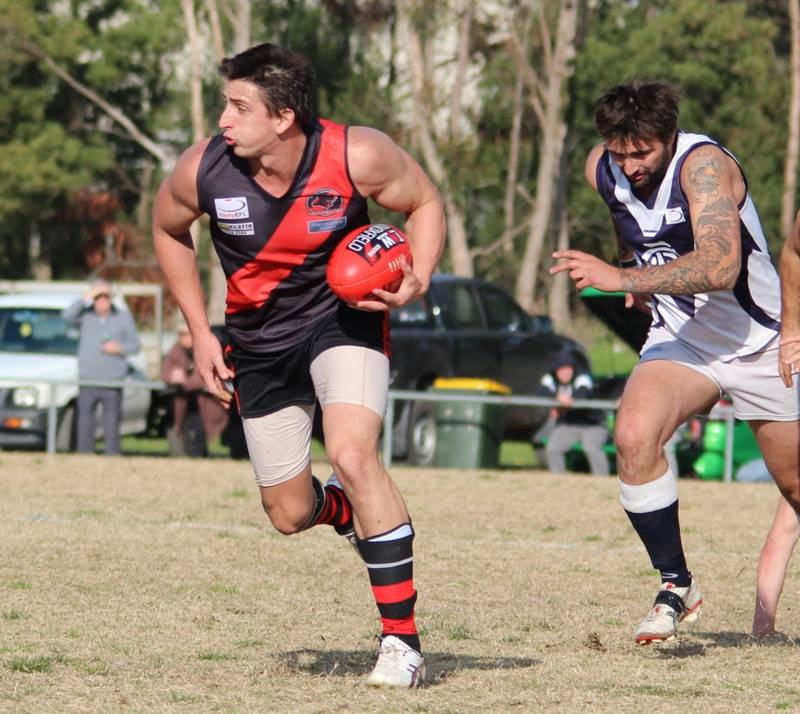 Footballer carrying the ball away from an opponent