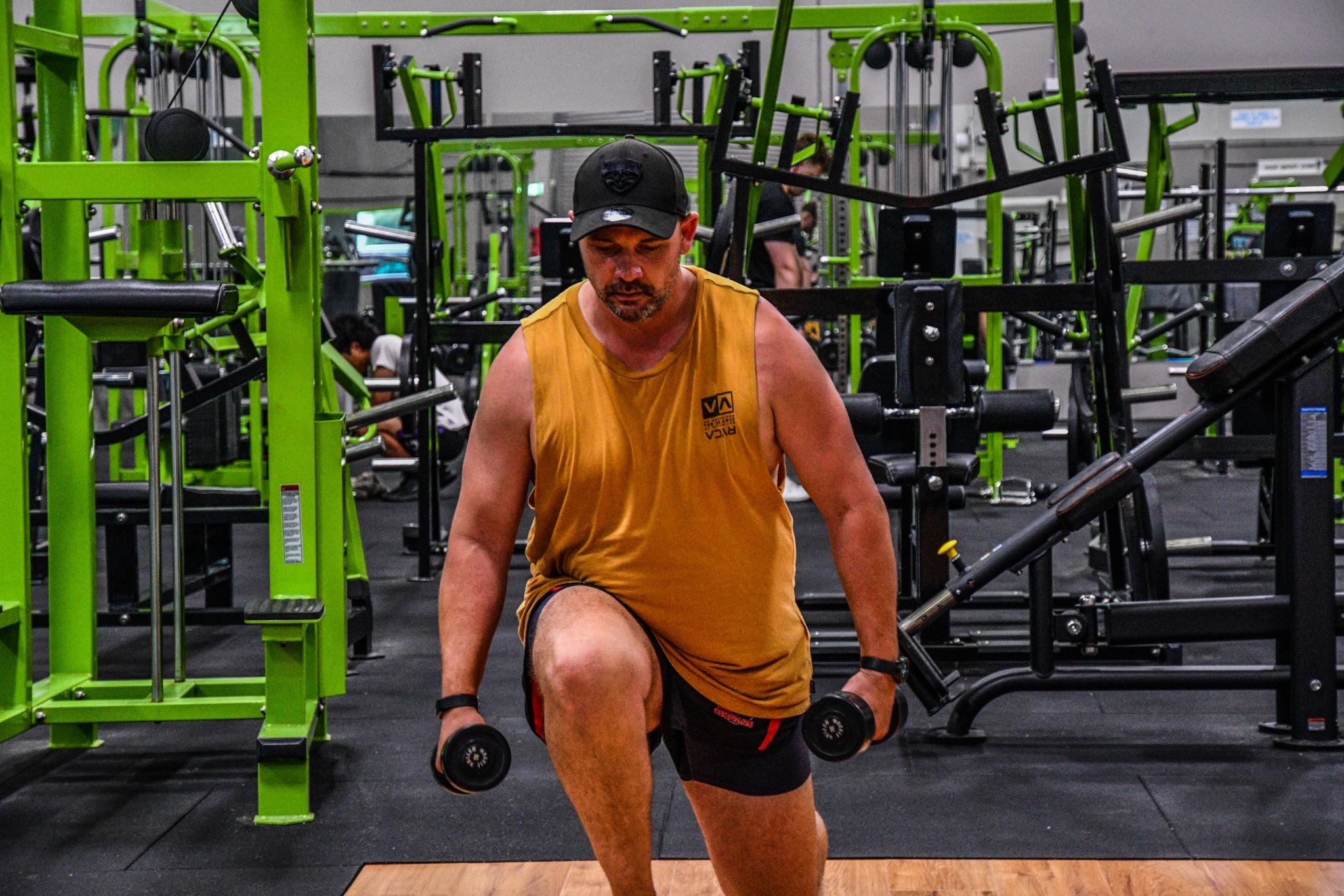 Troy training in a lunge position while holding dumbbells