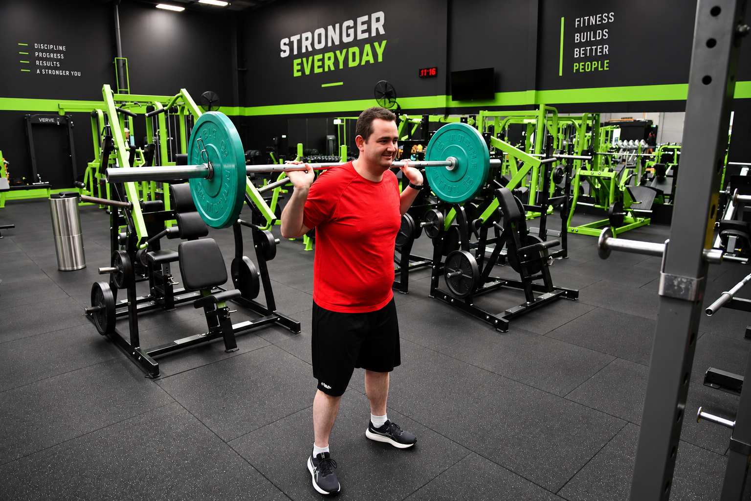 Jessie Vickery smiling with a barbell across his shoulders at Lifechoice Fitness